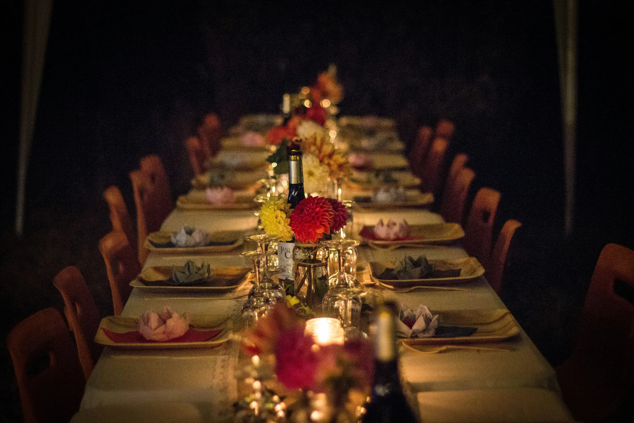 A long table laid with candles before the evening begins